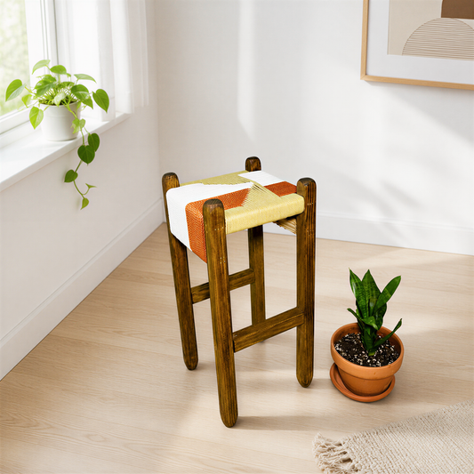 a wooden stool with a colorful cushion, placed on a wooden floor next to a potted plant.