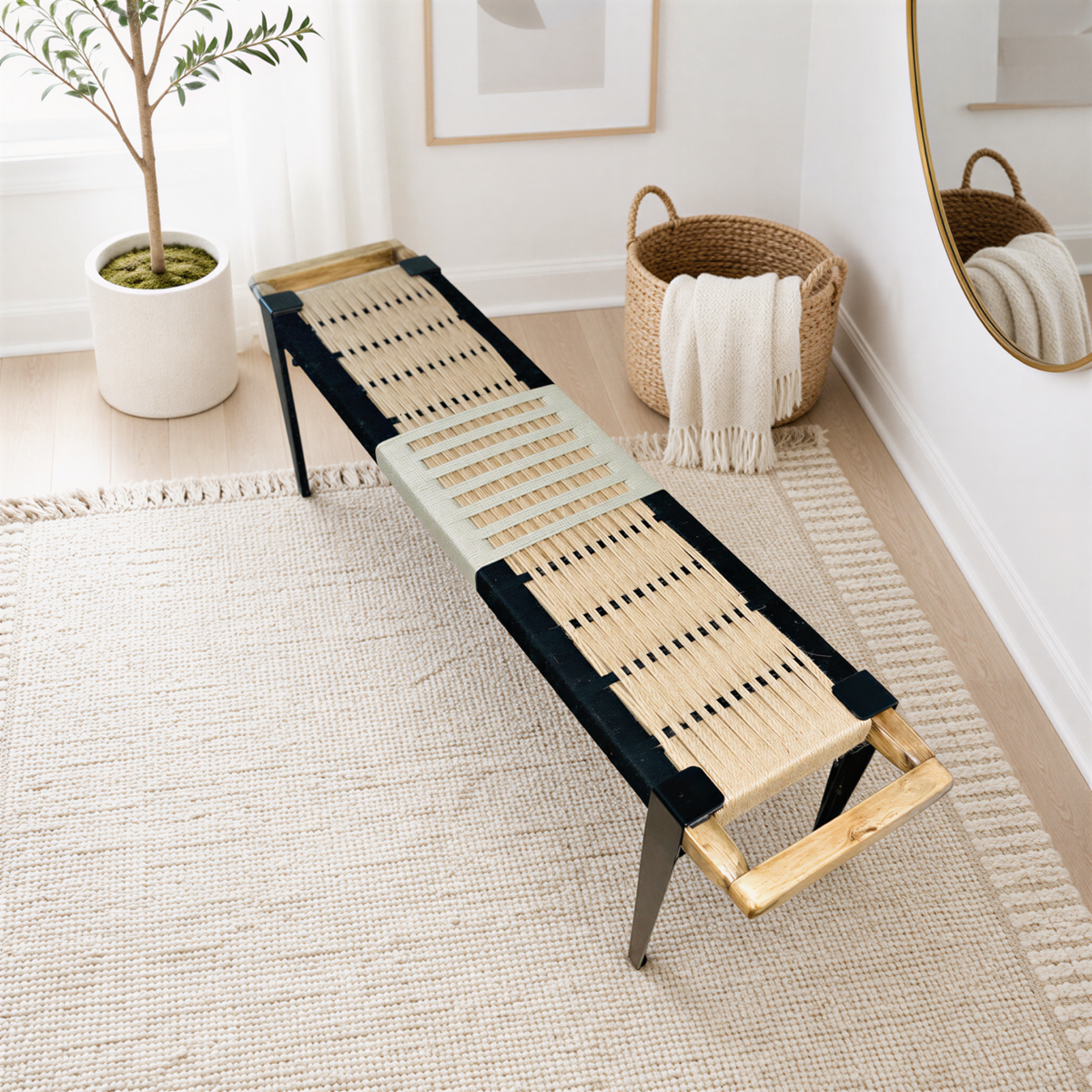 a modern bench with a woven seat and black metal frame, placed on a beige rug in a room with a large mirror and a potted plant.