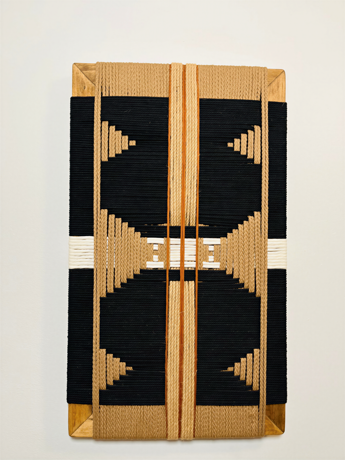 a decorative piece with a striking black and gold geometric pattern. The design consists of a central motif surrounded by a symmetrical arrangement of smaller geometric shapes, creating a visually appealing and intricate design.