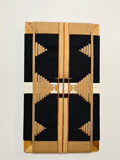 a decorative piece with a striking black and gold geometric pattern. The design consists of a central motif surrounded by a symmetrical arrangement of smaller geometric shapes, creating a visually appealing and intricate design.