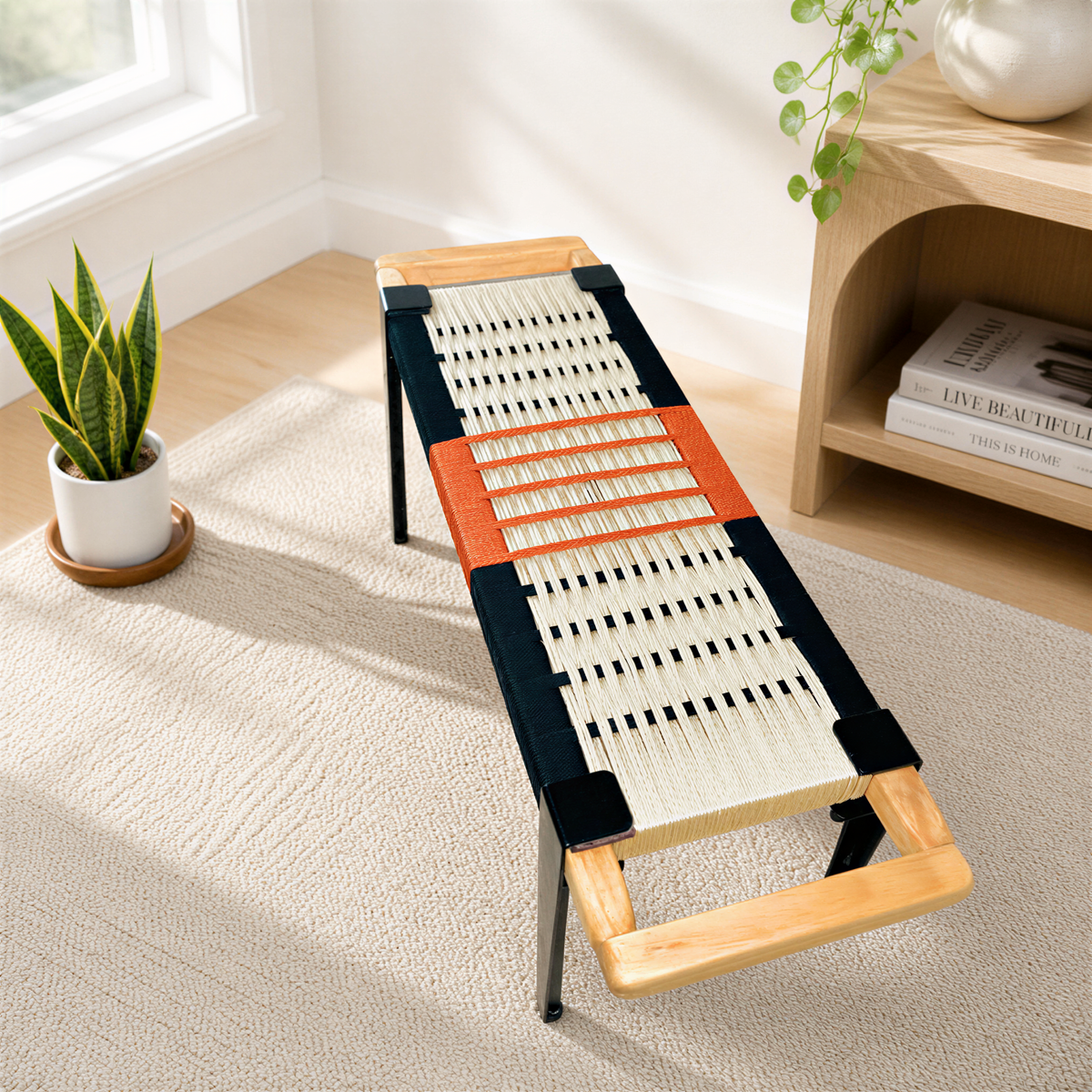 a modern bench with a woven seat and wooden frame, placed on a beige carpet in a room with a window and a plant.