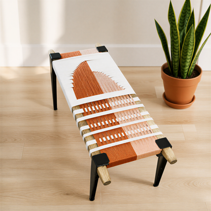 a modern bench with a woven seat and legs, placed on a wooden floor next to a potted plant.