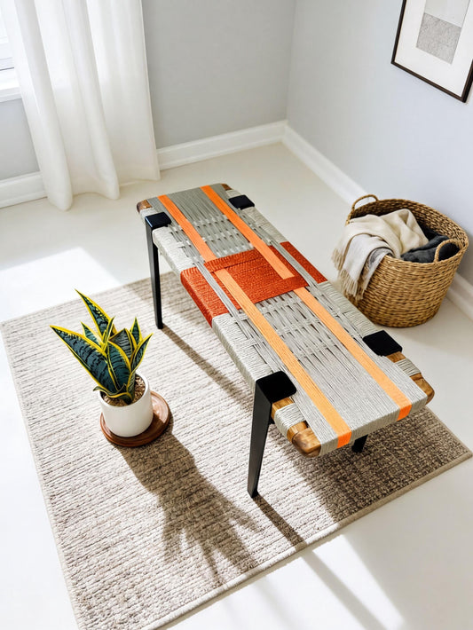 a modern, woven bench with orange and gray stripes, placed on a gray rug in a room with a window and a basket.