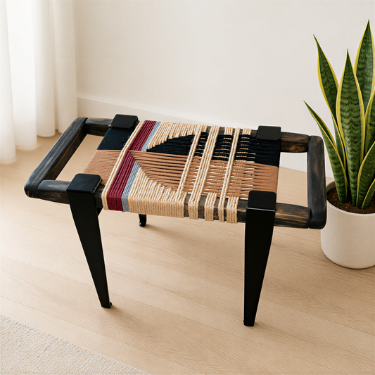 a woven bench with a wooden frame, placed on a wooden floor next to a potted plant.