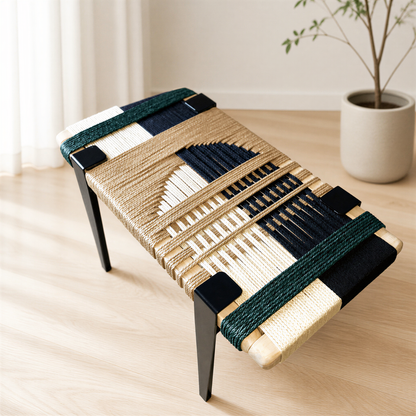 a woven bench with a geometric pattern in shades of blue, white, and beige. The bench is placed on a wooden floor, and there is a potted plant in the background.