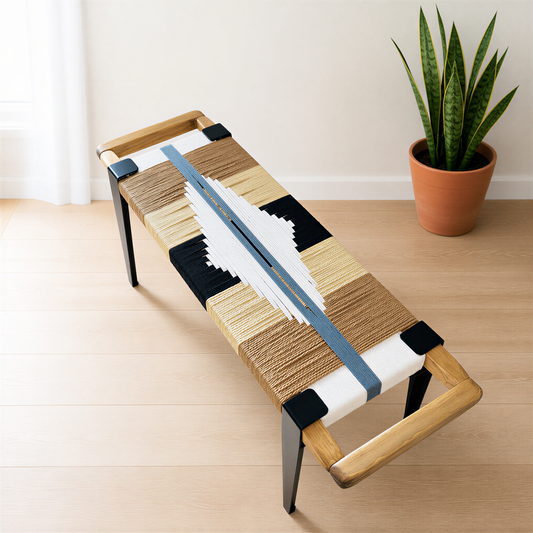a wooden bench with a woven seat and backrest, placed on a wooden floor next to a potted plant.