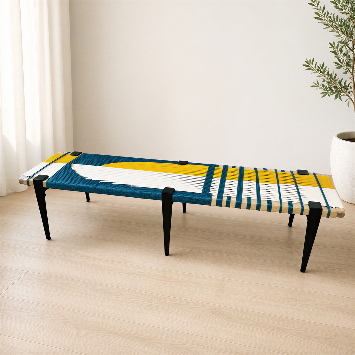 a long, colorful bench with a blue and yellow design on the seat, placed on a wooden floor against a white wall.